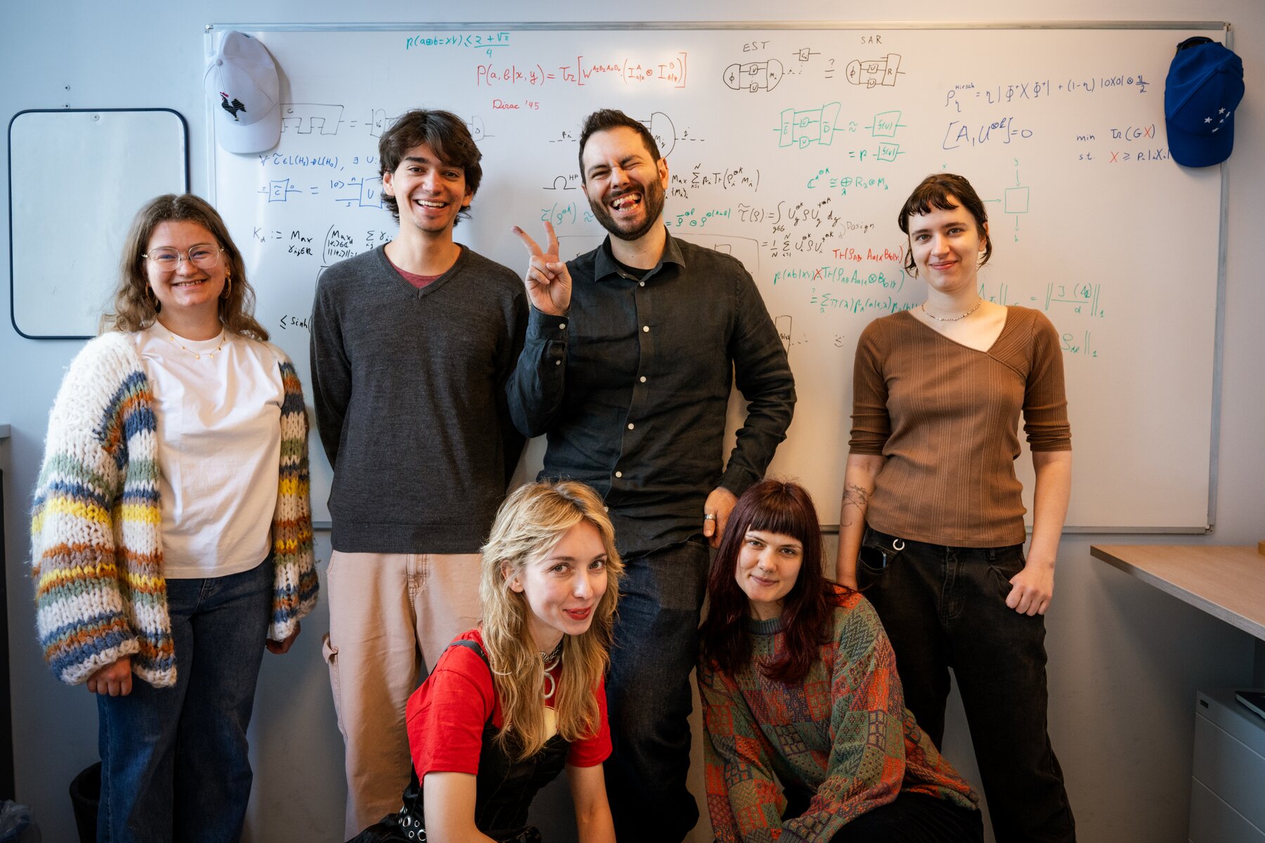 Research group posing in front of a whiteboard.