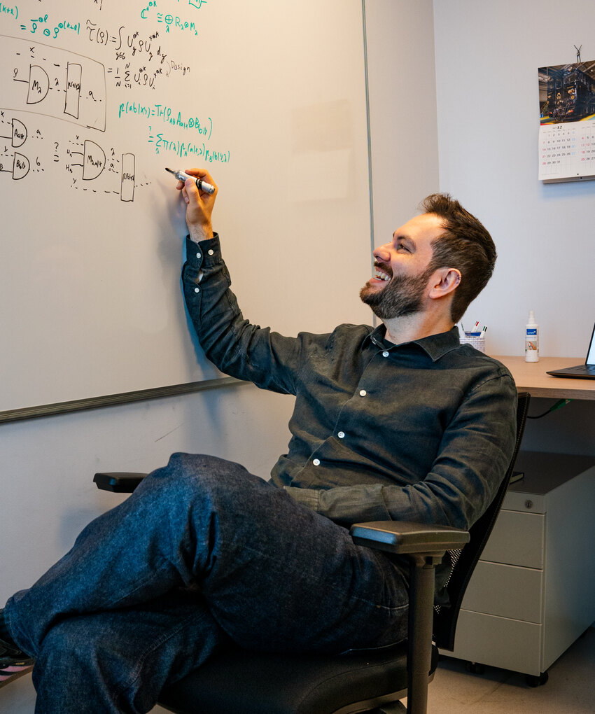 Marco Túlio Quintino writing on a whiteboard in his office.